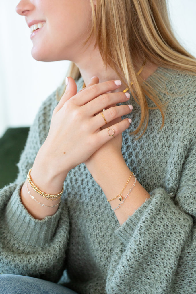 girl displays rings and bracelets from permanent jewelry in Alma, Michigan