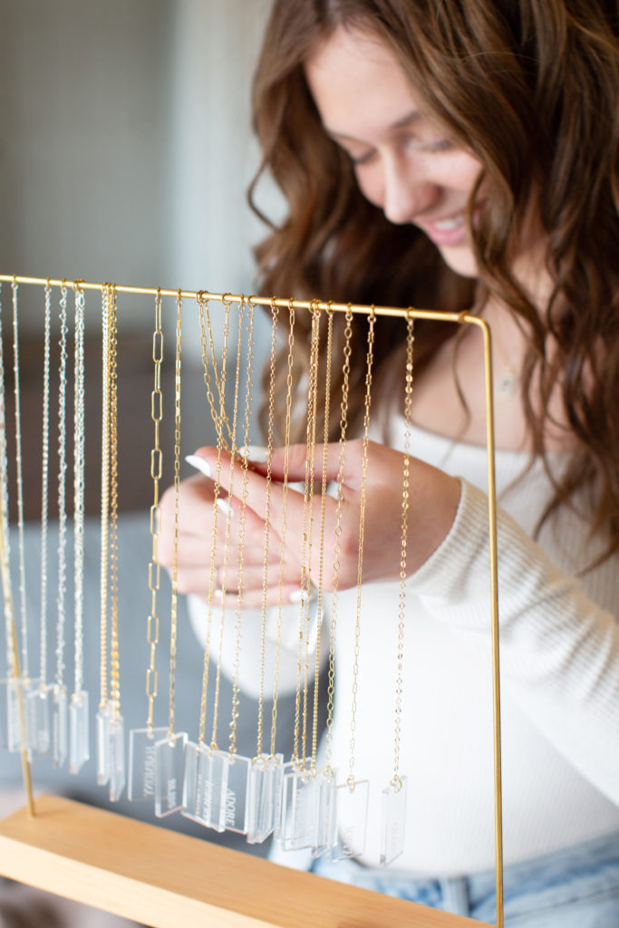teen looks at chain options of permanent jewelry in Alma, Michigan